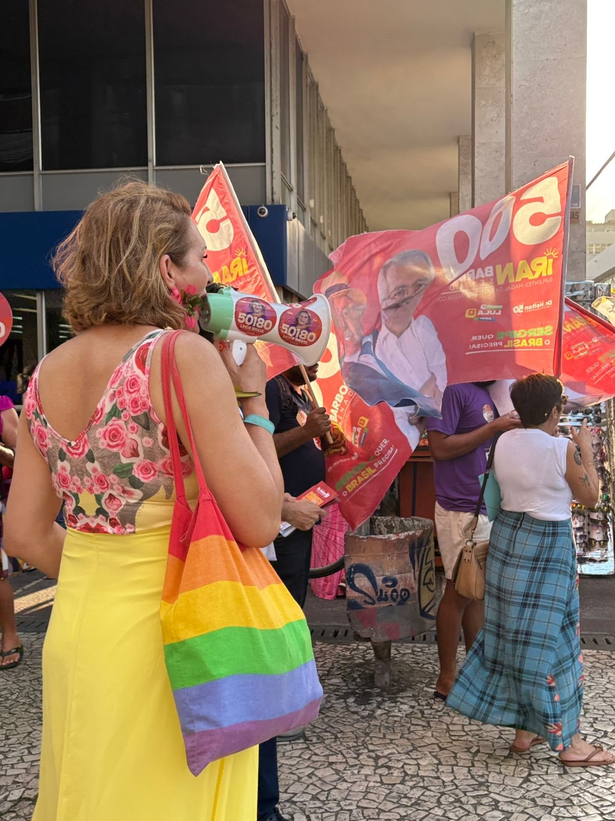 Linda Brasil diante das bandeiras da campanha no Centro de Aracaju